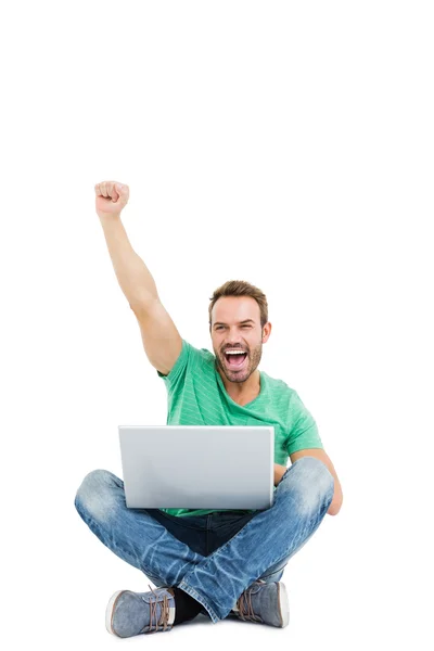 Man raising fist while using laptop — Stock Photo, Image