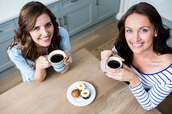 Vriendinnen houden koffiemokken — Stockfoto