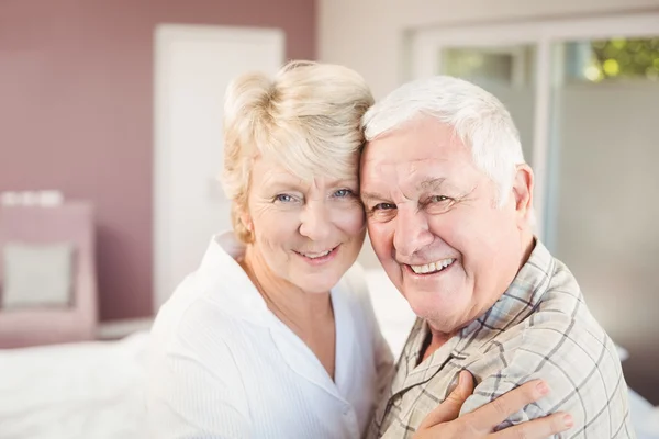 Porträt eines glücklichen Paares, das sich im Schlafzimmer umarmt — Stockfoto