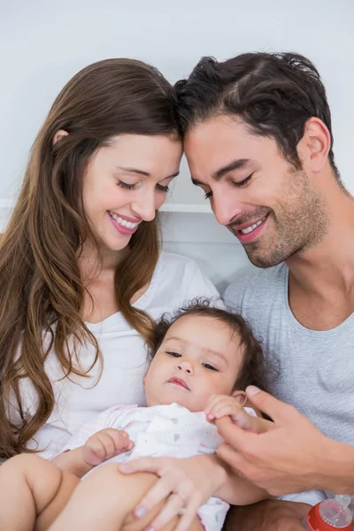 Крупный план счастливой пары с ребенком на кровати — стоковое фото