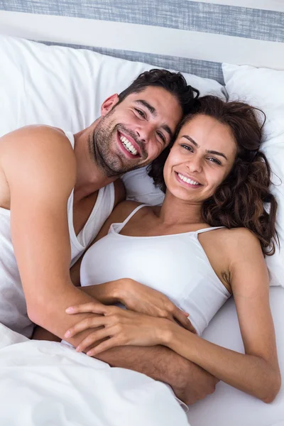 Веселая пара отдыхает на кровати — стоковое фото