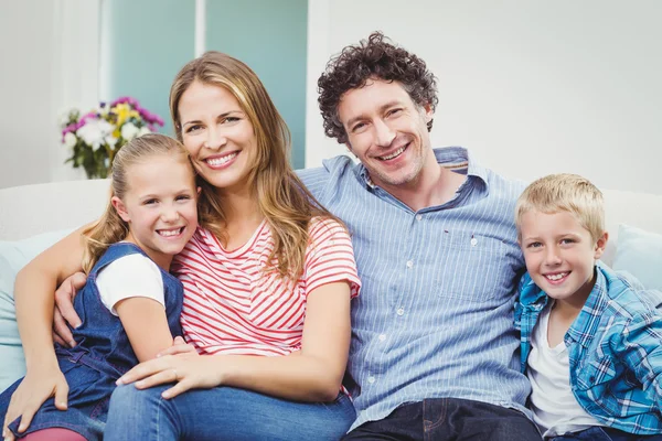 Couple sitting with children on sofa Royalty Free Stock Photos