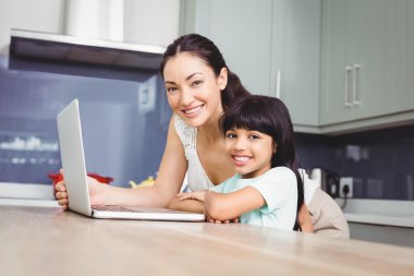 mother and daughter working on laptop  clipart