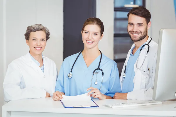 Equipo médico de pie en el escritorio de la computadora —  Fotos de Stock