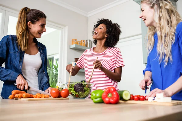 Friends laughing while preparing food — Stock Photo, Image