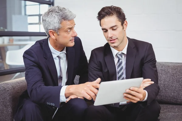 Affärsmän diskutera medan du håller tablet — Stockfoto