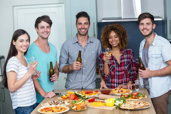 Amici godendo di alcol e pizza a tavola — Foto Stock