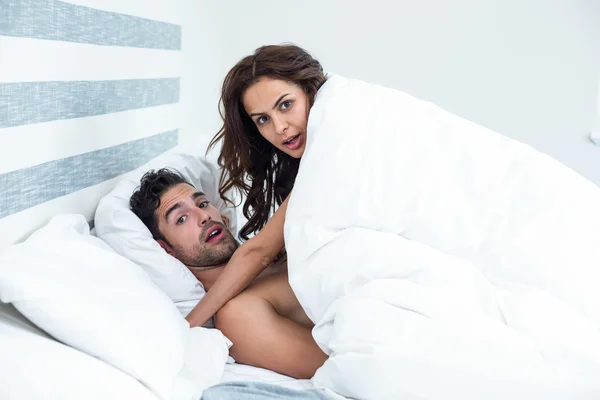 Surpreendido jovem casal desfrutando na cama — Fotografia de Stock