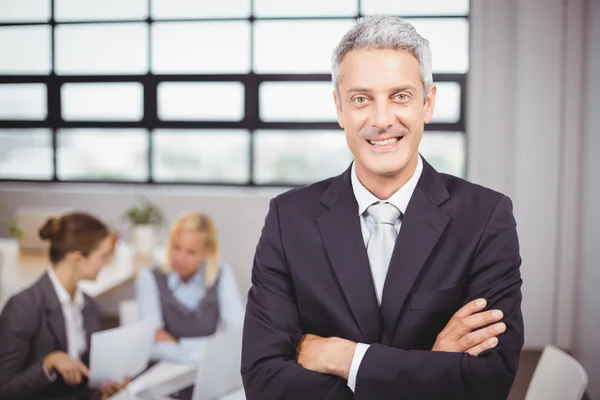 Empresario con colegas de fondo — Foto de Stock