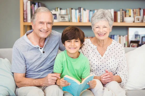 Grootouders met kleinzoon boek houden — Stockfoto