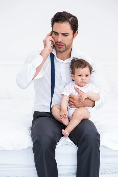 Far prata mobil telefon med baby — Stockfoto