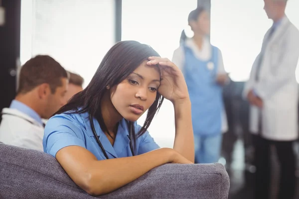 Tensed doctor sitting on sofa — Stock Photo, Image