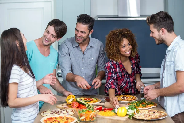 Amici felici che preparano la pizza a casa — Foto Stock