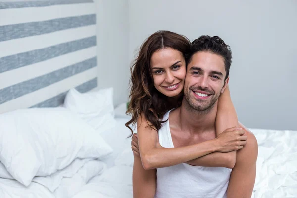 Wife embracing husband on bed