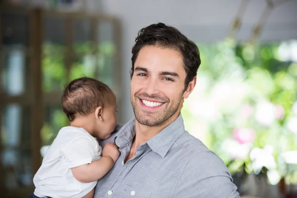 Portret van vrolijke vader baby uitvoering — Stockfoto