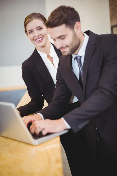Pessoas de negócios usando laptop por balcão — Fotografia de Stock