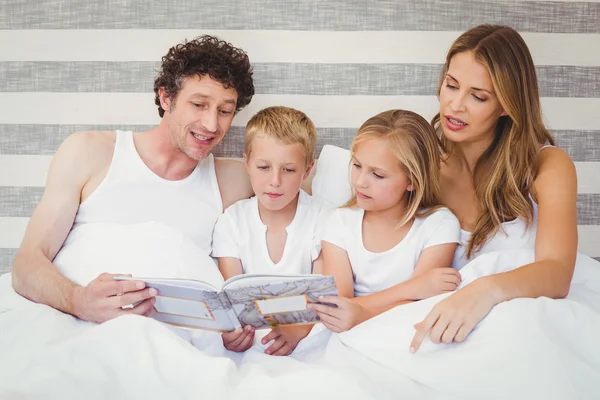 Livro de leitura da família na cama — Fotografia de Stock