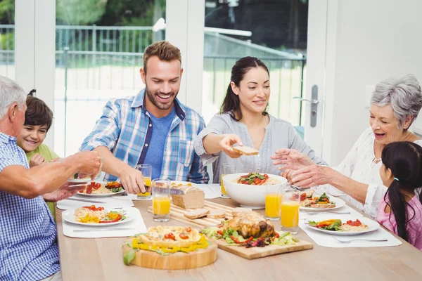 ダイニング テーブルに食べ物を持っている家族 — ストック写真