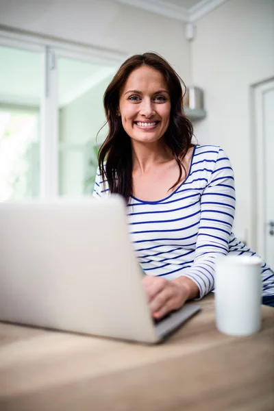 Mulher trabalhando no laptop enquanto segurando coffe — Fotografia de Stock