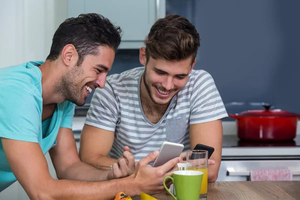 Alegre amigos do sexo masculino usando telefone — Fotografia de Stock