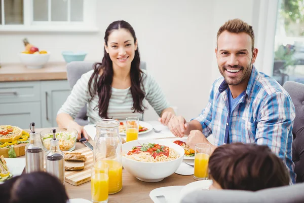 Föräldrar med barn sitter vid matbordet — Stockfoto
