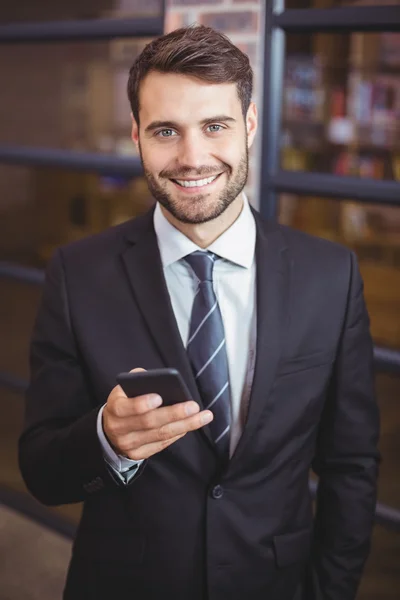 Uomo d'affari che utilizza il cellulare in ufficio — Foto Stock