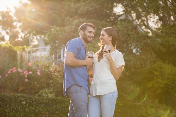 Jovem casal de pé com vinho — Fotografia de Stock