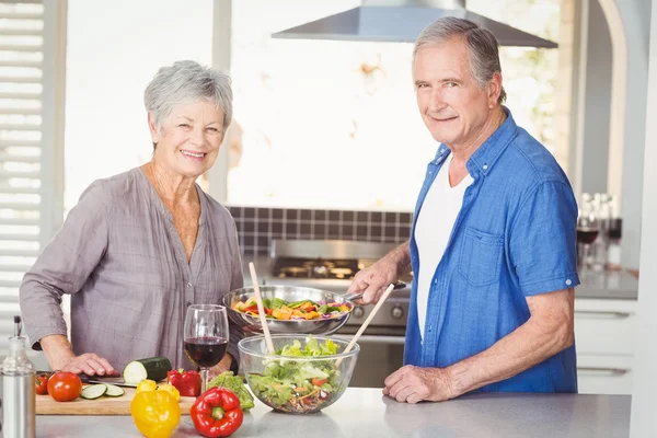 Portrait of happy senior couple preparing food — Stock Photo, Image