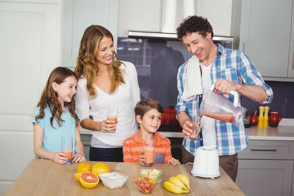 Pai derramando suco de frutas em vidro — Fotografia de Stock