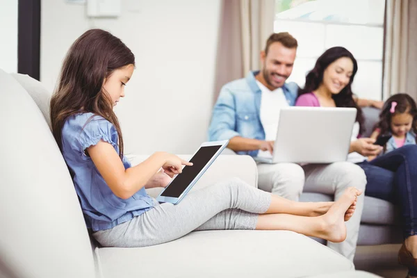 Ragazza che utilizza tablet digitale sul divano — Foto Stock