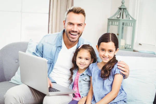 Pai e filhas procurando no laptop — Fotografia de Stock