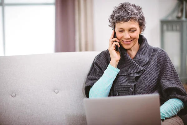 Kvinna med laptop prata telefon — Stockfoto