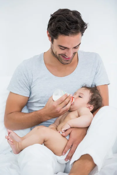 Padre alimentando leche a su hija en casa —  Fotos de Stock