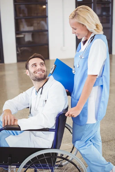 Médico em cadeira de rodas interagindo com colega — Fotografia de Stock