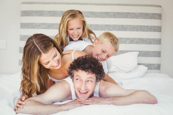 Família desfrutando na cama em casa — Fotografia de Stock