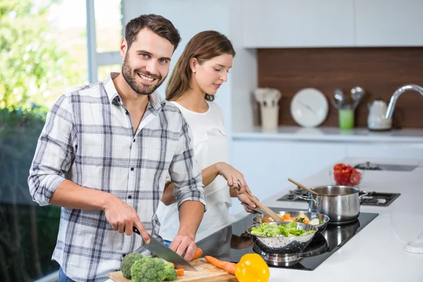 Мужчина помогает женщине готовить еду — стоковое фото