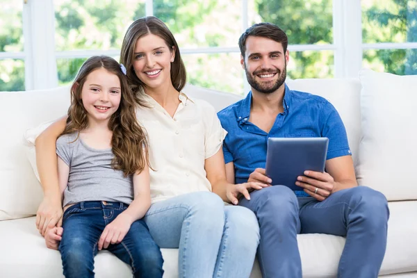 Família sentada no sofá com tablet digital — Fotografia de Stock