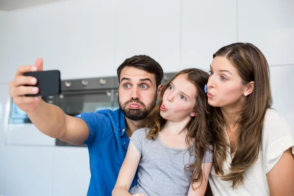 Familjen att göra ansikten och klicka på selfie — Stockfoto