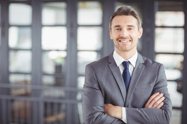 Affärsman med armarna korsade i office — Stockfoto