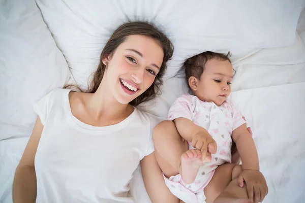Высокий угол обзора счастливой женщины, лежащей с дочерью — стоковое фото