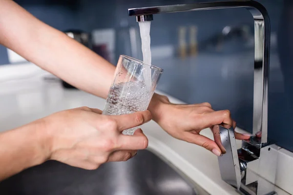 Vrouw vullen water in glas — Stockfoto