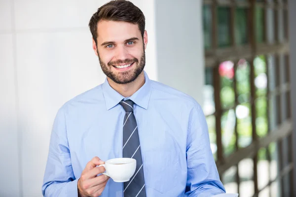 Empresário segurando xícara de café — Fotografia de Stock