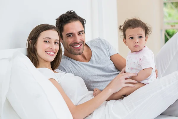 Couple with daughter on bed — Stock Photo, Image