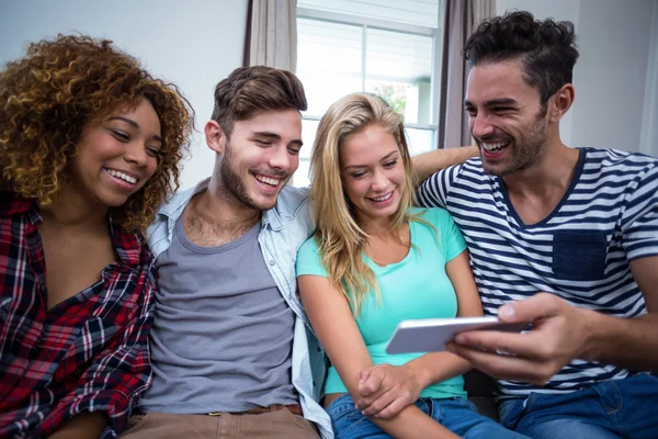 Freunde schauen in Handy auf Sofa — Stockfoto