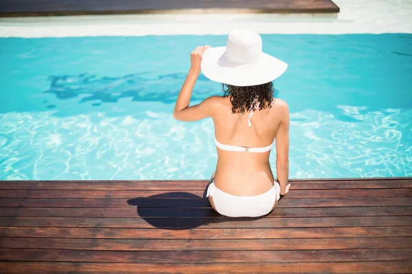 Vue arrière de la femme portant un bikini blanc et un chapeau assis près du caca — Photo