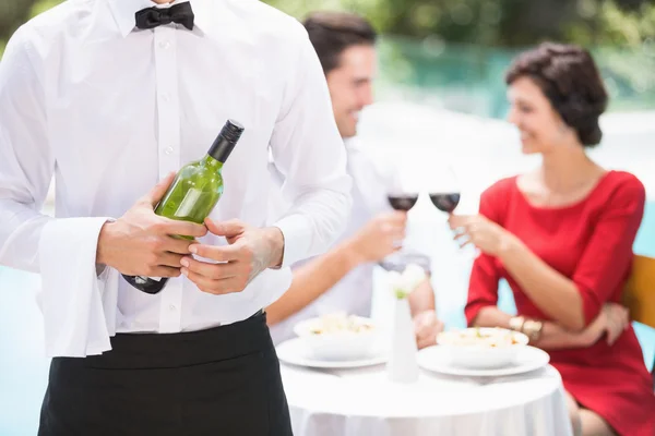 Camarero sosteniendo botella de vino —  Fotos de Stock