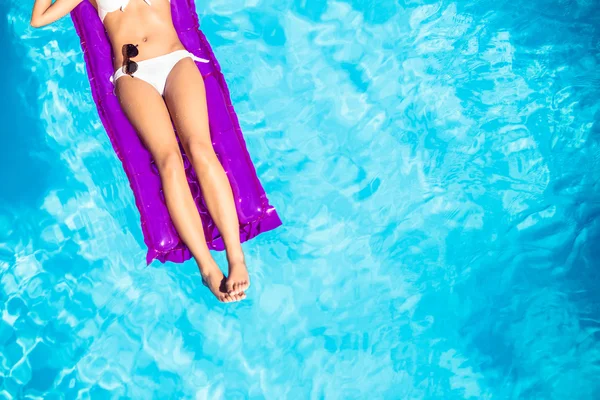 Kvinnan i vit bikini liggande på luftmadrass — Stockfoto