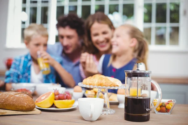 バック グラウンドで幸せな家族中テーブルの上に食べ物 — ストック写真