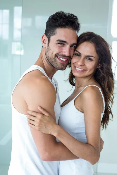 Casal sorrindo enquanto abraça em casa — Fotografia de Stock