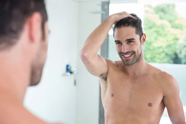 Jovem sorrindo enquanto olha no espelho — Fotografia de Stock